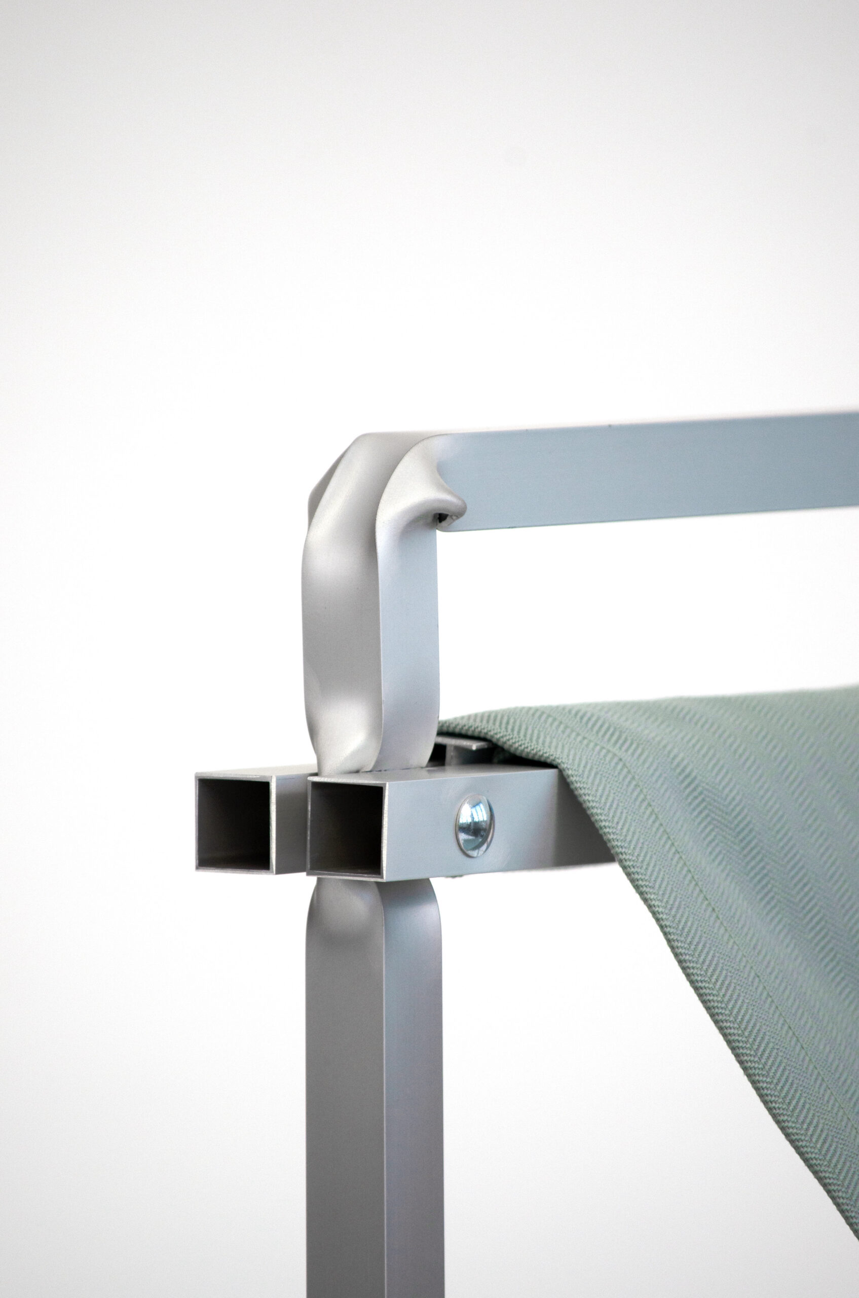 Detail der Rückenlehne eines Aluminium Stuhls vor einem weißen Hintergrund